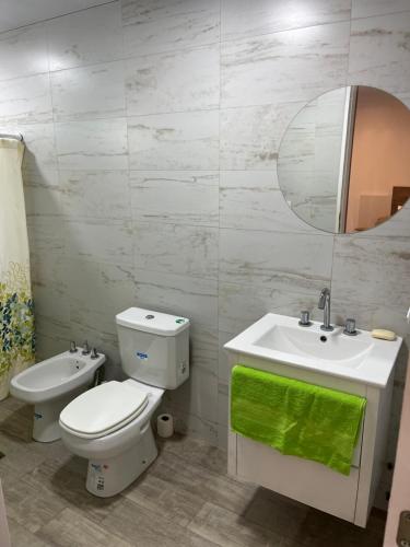 a bathroom with a toilet and a sink and a mirror at Moderno DEPARTAMENTO temporal SAN JORGE in San Jorge
