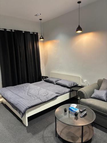 een slaapkamer met een bed, een bank en een tafel bij استديو بطابع هادي in Al Khobar