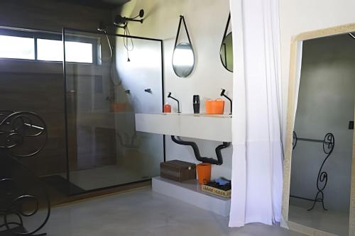 a bathroom with a shower with a sink and a mirror at Casa Rústica - Próx à Praia in Saquarema