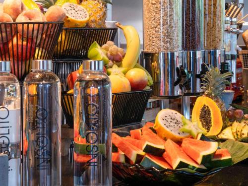 Un montón de fruta en una mesa con dos botellas. en Novotel Madrid City Las Ventas, en Madrid