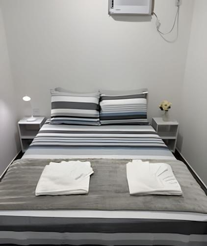 ein Schlafzimmer mit einem Bett mit zwei weißen Handtüchern darauf in der Unterkunft Suíte aconchegante a 3 min da Praia do Pontal! (3) in Arraial do Cabo