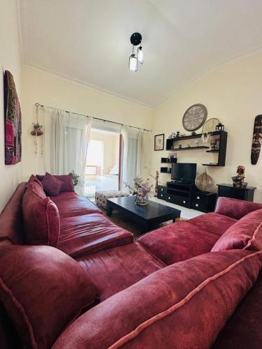ein Wohnzimmer mit einer großen roten Couch in der Unterkunft شاليه للايجار غرفتين مارينا 7 in El-Alamein