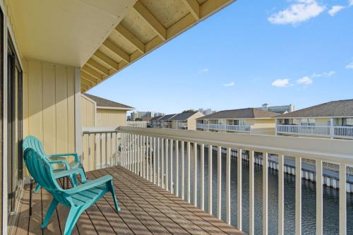 a balcony with a blue chair and a view of the water at Waterfront Summer Vacay Free Private Beach Chairs & Umbrella Sleeps 5 in Destin