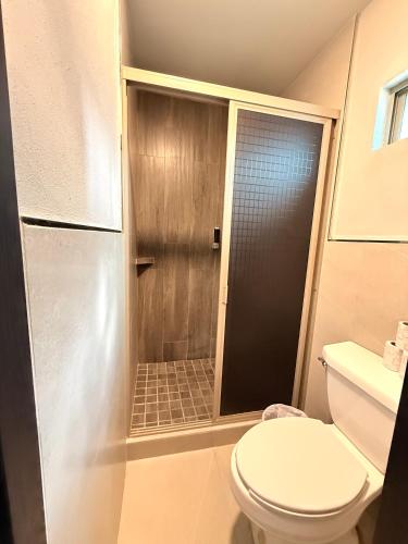 a bathroom with a toilet and a walk in shower at Hotel Las Vegas in Matamoros