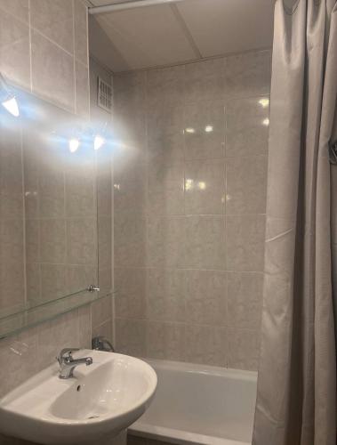 a bathroom with a sink and a tub and a mirror at Zakątek in Warsaw