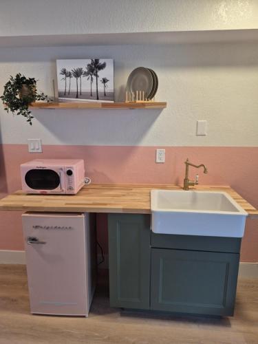 een keuken met een aanrecht met spoelbak en magnetron bij Abode Beach House in Clearwater Beach