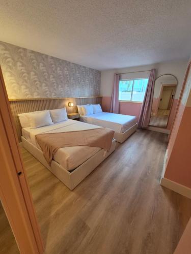 een slaapkamer met twee bedden en een raam bij Abode Beach House in Clearwater Beach