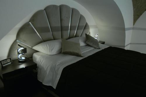 una camera da letto con un letto grande con una grande testiera di Pietrarsa Street Room a Portici