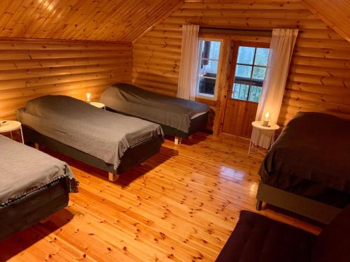 a room with two beds in a log cabin at Villa Sofia in Otalampi
