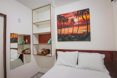 a bedroom with a bed and a painting on the wall at Apartamento da Joana - 2ª Praia, Morro de SP in Morro de São Paulo