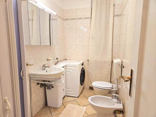 une salle de bain blanche avec un lavabo et des toilettes dans l'établissement Stradivarius House, à Crémone