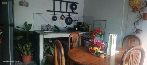 una cucina con un tavolo con sedie e una stufa di Sunset guest house a San Juan del Sur