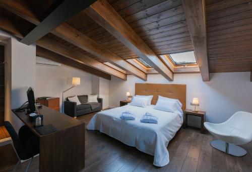 a bedroom with a large white bed and a couch at Bonansa Country Hotel in Bonansa