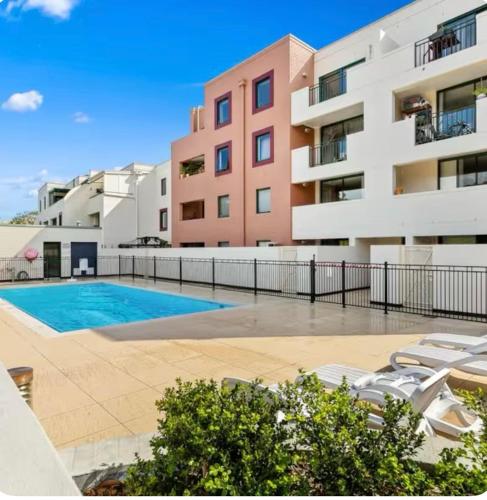 an apartment with a swimming pool in front of a building at NEWTOWN - HEART OF - Bohemian Creative Space in Sydney
