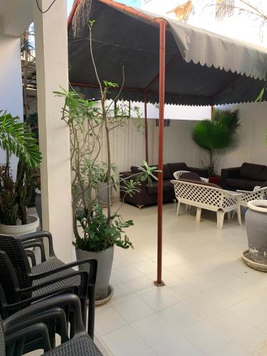 un patio con un ombrello nero e alcune piante di Keur Antou a Dakar