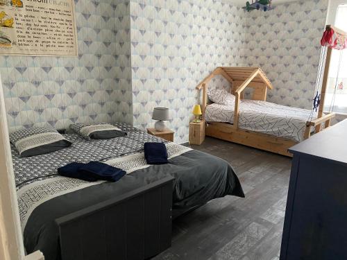 1 Schlafzimmer mit 2 Einzelbetten und einer Wand in der Unterkunft maison de ville dans le perche in Senonches