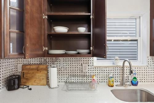 a kitchen counter with a sink and cabinets with dishes at 4 BR • Vaulted Living • Sleeps 11 in Jersey City