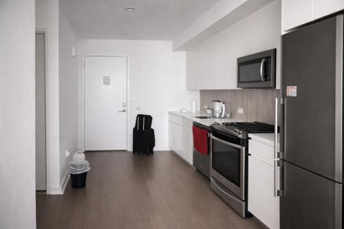 een keuken met een fornuis en een koelkast bij Elegant Long Island City Studio with Skyline Views in Roosevelt Island