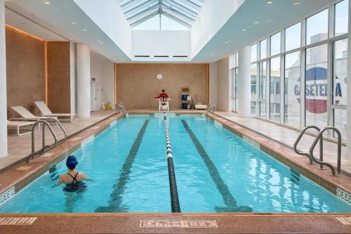 een persoon die in een zwembad in een gebouw zwemt bij Elegant Long Island City Studio with Skyline Views in Roosevelt Island