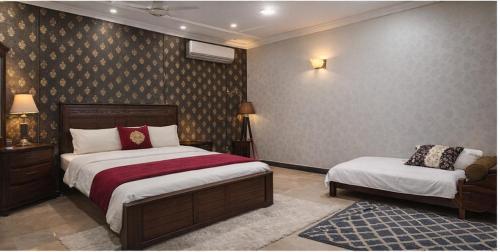 a bedroom with two beds and a chair in it at Komal Residency in Islamabad