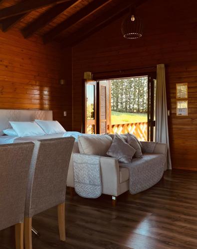 a living room with a couch and a bed at Pousada Recanto do Lago in Cambará