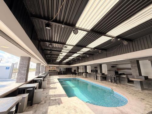 una piscina in un edificio con tavoli e sedie di Hotel Las Vegas a Matamoros