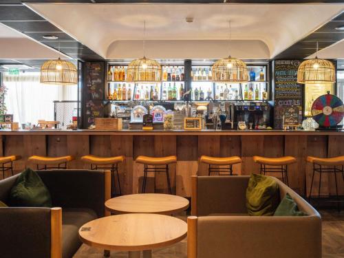 a bar with chairs and tables in a restaurant at Novotel Bordeaux Centre Ville in Bordeaux