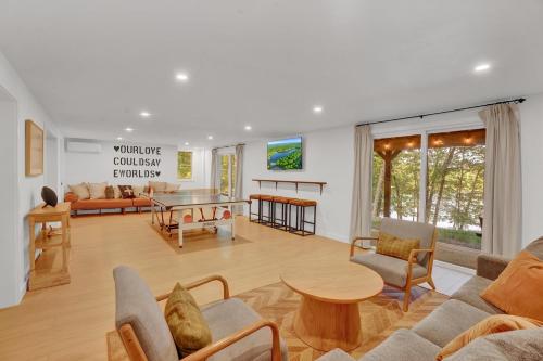 a living room with a couch and a table at LUX Lakefront, Pool, Hot Tub, Game Room, FIFA 2026 in Bushkill