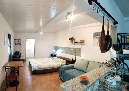 een woonkamer met een bank en een bed bij Casa 99 in Barbéns, Miranda do Corvo in Miranda do Corvo