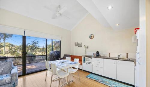 a kitchen and dining room with a table and chairs at Relaxing Beach shack at the Footprints complex in Preston Beach