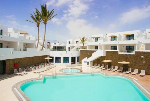 a pool in front of a building with a resort at Aqua Suites in Puerto del Carmen