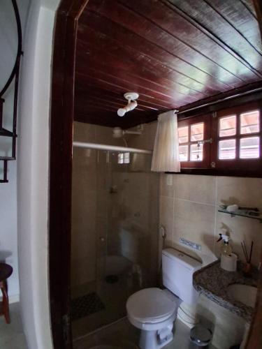 a bathroom with a toilet and a glass shower at Chalé 4 Quartos Casa Jasmin in Chã Grande