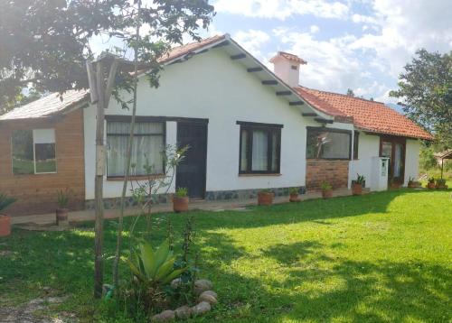 a house with a green lawn in front of it at Hospedaje Rural Pistacia Vera - Villa de Leyva in Villa de Leyva