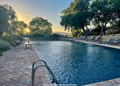 - une piscine avec des chaises et une table à côté dans l'établissement Cortijo Bablou, à Arcos de la Frontera