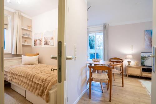 a bedroom with a bed and a table and chairs at _ARW3_ _ Ferienwohnung Kossmann in Niendorf