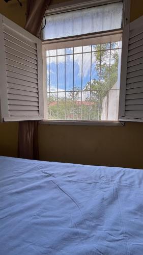 una camera da letto con un letto e una grande finestra di Chalé Pitaya 06 a Piranhas