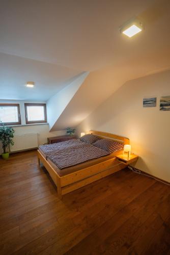 a bedroom with a large bed in a attic at Apartmán Pivoňka in Kvilda