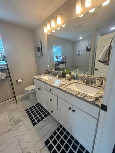 a bathroom with a sink and a mirror at NWA Modern Stay in Springdale