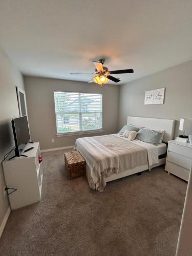 a bedroom with a bed and a ceiling fan at NWA Modern Stay in Springdale