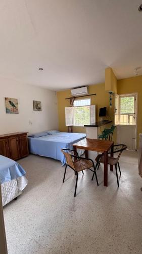 ein Schlafzimmer mit einem Bett, einem Tisch und Stühlen in der Unterkunft Chalé Pitaya 05 in Piranhas