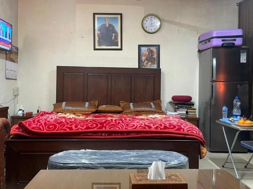 ein Schlafzimmer mit einem großen Bett mit einer roten Decke in der Unterkunft Secure Private Apartment Privacy Guaranteed in Lahore