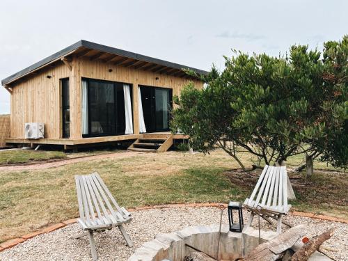 twee witte stoelen voor een huis bij Casa Franca in José Ignacio