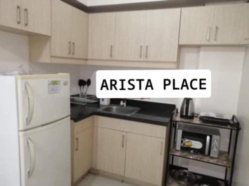una cucina con mobili bianchi e un frigorifero bianco di Staycation Condo in Manila a Manila