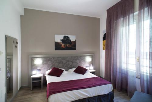 a bedroom with a large bed with red pillows at Hotel Salus in Milan