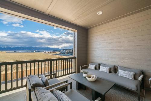 een balkon met banken, een tafel en een groot raam bij Modern Retreat for Groups with Majestic Views in Belgrade