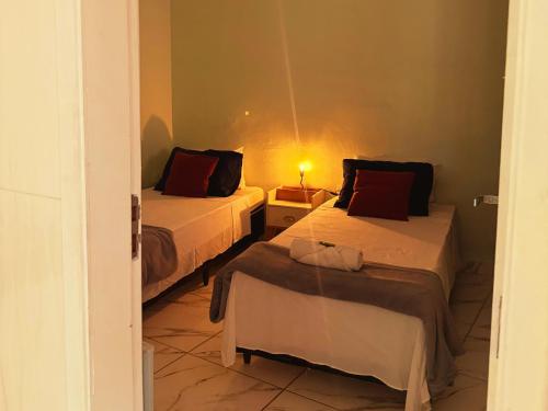 Camera piccola con 2 letti e una lampada di Golden Garden Hostel a Ubatuba