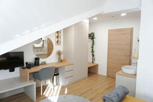 ein Badezimmer mit Waschbecken und ein Schreibtisch mit Fernseher in der Unterkunft Gostisce Ulipi in Slovenske Konjice