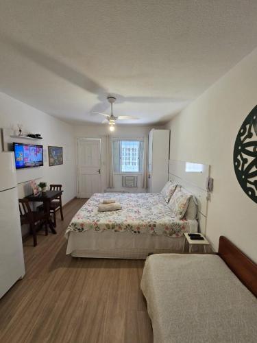 a bedroom with a large bed and a dining room at Flat Privativo Rua das Pedras in Búzios