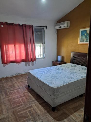 a bedroom with a bed and a red window at Ebenezer in Playa Hermosa