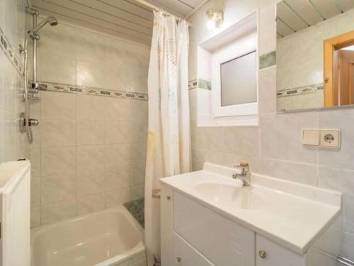 een witte badkamer met een wastafel en een bad bij Zederhaus in Mariapfarr